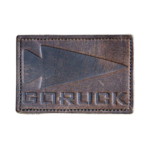 Custom engraved leather patch featuring the Garuck logo on premium dark brown leather with embossed detailing and stitched border for hats, backpacks, jackets, and outdoor gear