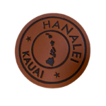 Custom engraved round leather patch featuring the Hawaii and Kauai islands design on premium brown leather with laser-etched details for hats, bags, jackets, and outdoor apparel